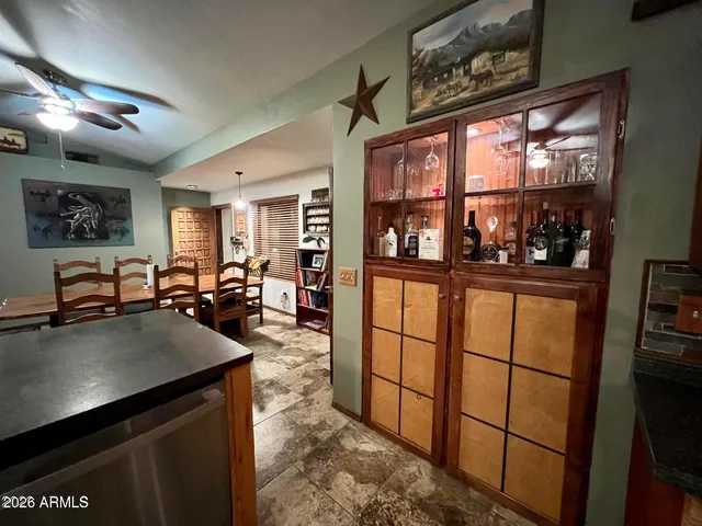 a living room with furniture a flat screen tv and a refrigerator