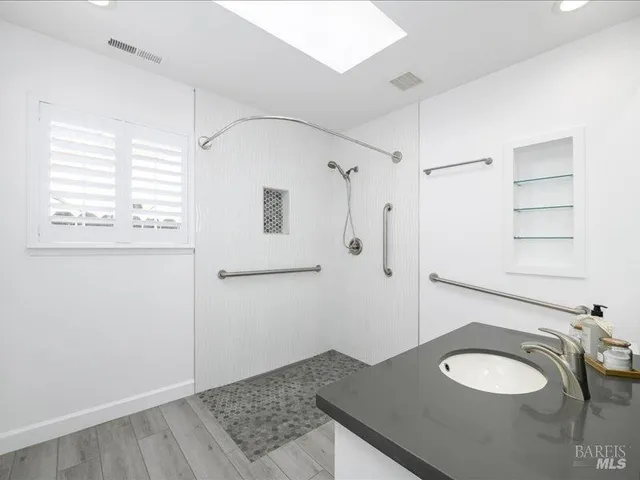 a bathroom with a granite countertop sink and a mirror