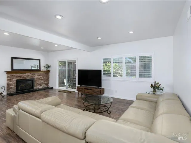 a living room with furniture a fireplace and a flat screen tv
