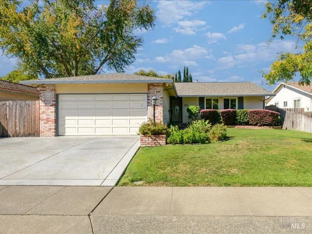 a front view of a house with a yard and potted plants