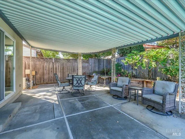 a view of patio with a table and chairs and a barbeque