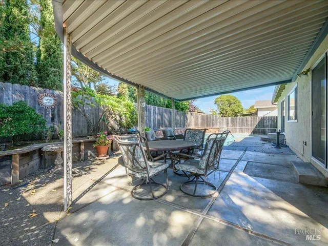 a view of a patio with table and chairs potted plants with wooden floor and fence
