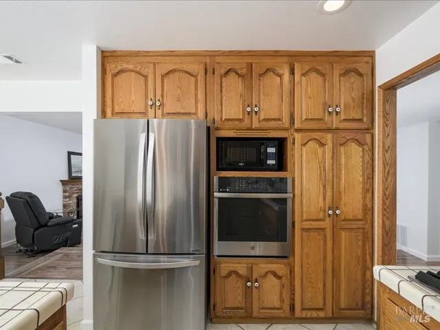 a metallic refrigerator freezer sitting in a kitchen