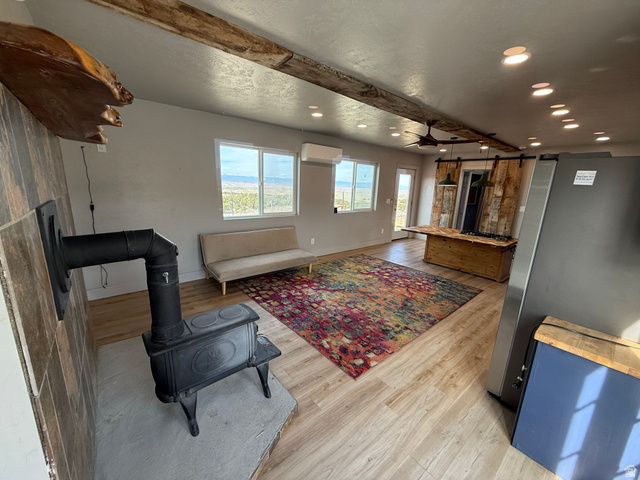 14183 High Mesa Loop Duchesne, UT 84021 - Photo 29 of 56 Living area with light wood-type flooring, beamed ceiling, a wood stove, recessed lighting, and a ceiling fan