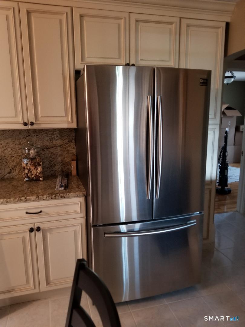 103 Windsor Street Enfield, CT 06082 - Photo 11 of 22 a metallic refrigerator freezer sitting in a kitchen