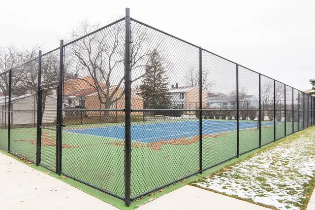 a view of swimming pool with outdoor seating and trees in the background