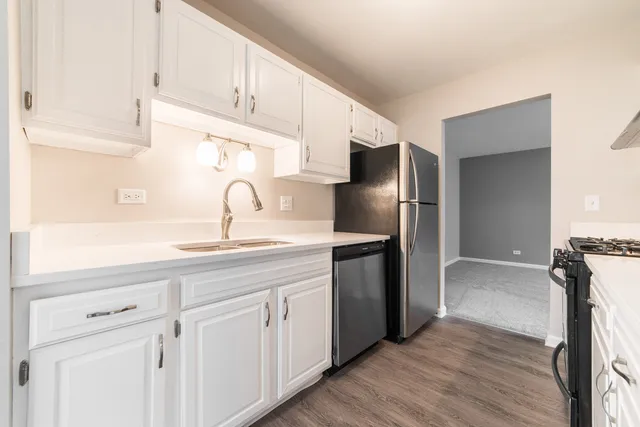 a kitchen with stainless steel appliances granite countertop a sink and a refrigerator