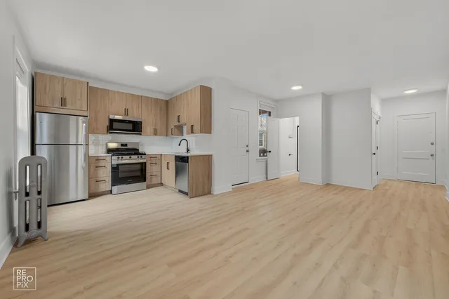 a kitchen with stainless steel appliances granite countertop a refrigerator and a stove top oven