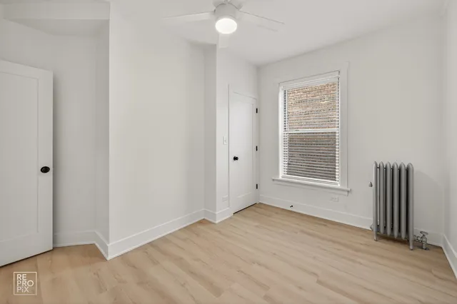 an empty room with wooden floor and a window