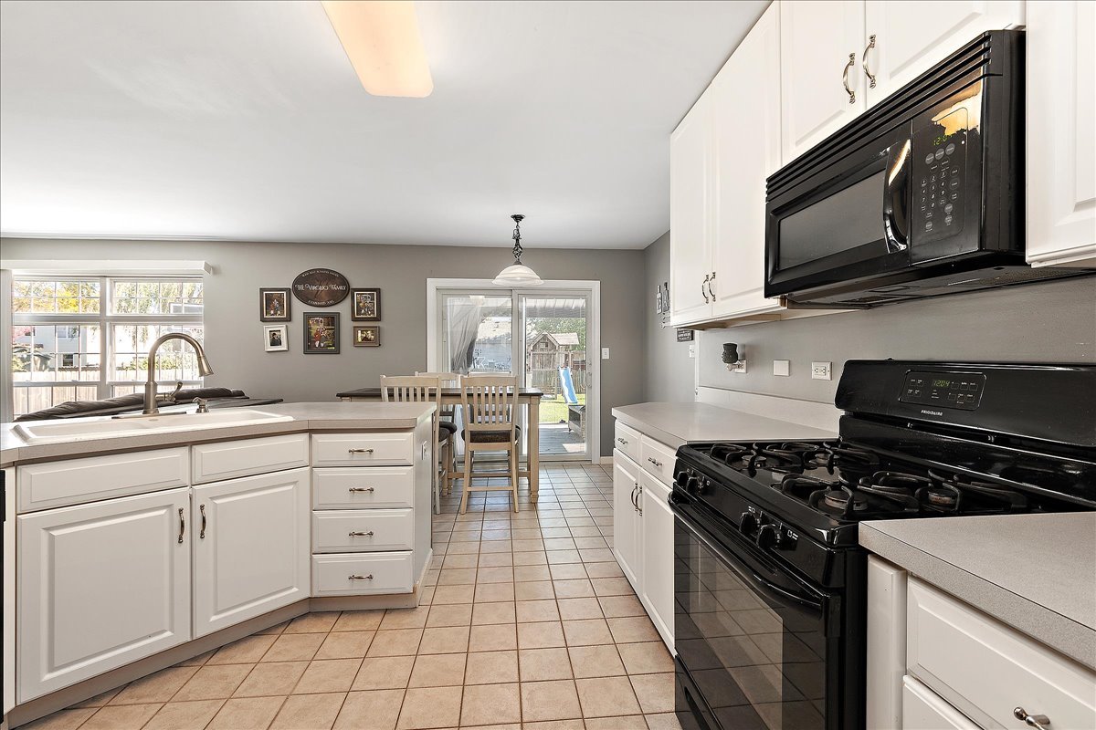 898 Meadowbrook Road Elwood, IL 60421 - Photo 4 of 30 a kitchen with stainless steel appliances a stove microwave and cabinets