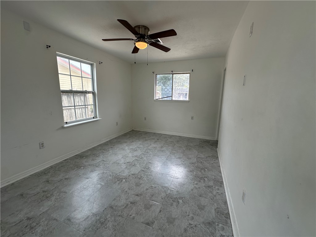 113 Lee Avenue Gregory, TX 78374 - Photo 13 of 22 an empty room with windows and ceiling fan view
