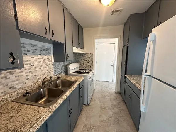 a kitchen with a sink stove and refrigerator