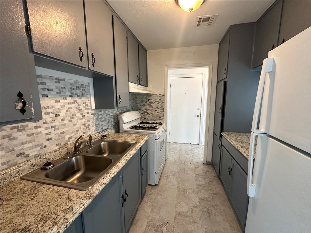 113 Lee Avenue Gregory, TX 78374 - Photo 4 of 22 a kitchen with a sink stove and refrigerator