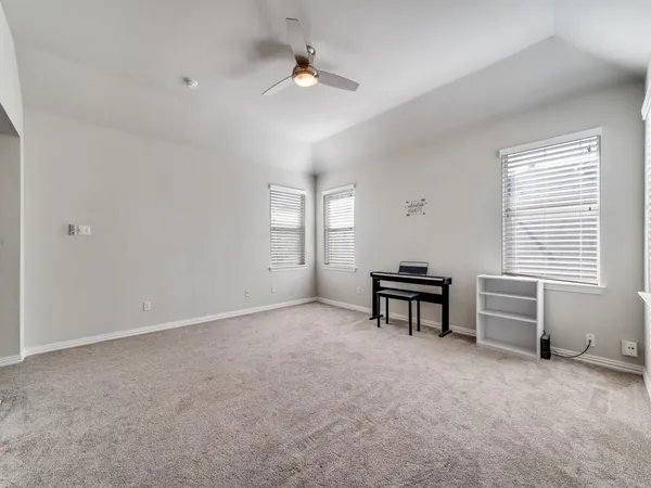 an empty room with windows and ceiling fan view