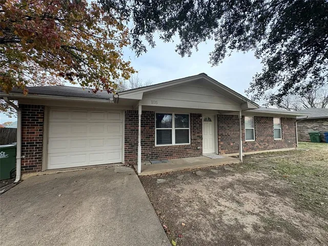 a front view of a house with a garden and yard