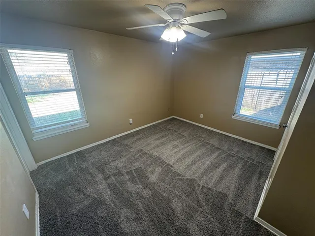 an empty room with closet and a chandelier fan