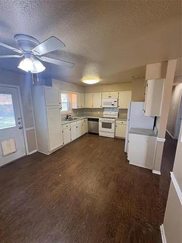a kitchen with cabinets and wooden floor