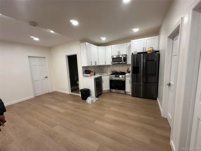 a kitchen with stainless steel appliances a stove a sink a refrigerator and a refrigerator