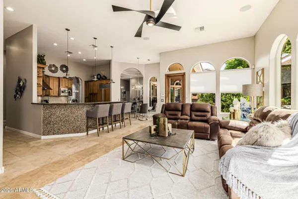 a living room with furniture a chandelier and a large window