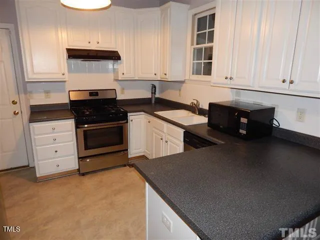 a kitchen with stainless steel appliances a stove a sink and cabinets
