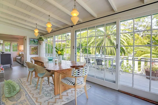 a view of a dining room with furniture large windows and wooden floor