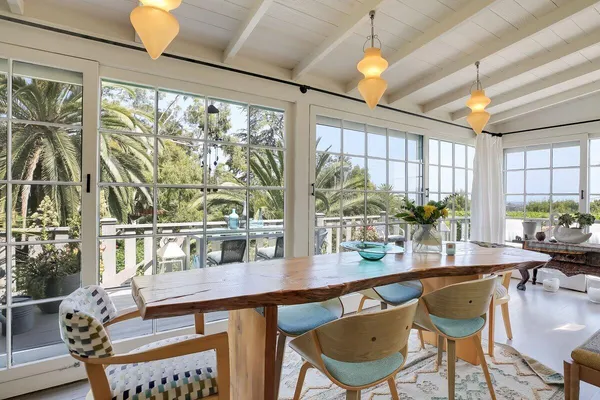 a dining room with furniture a chandelier and wooden floor
