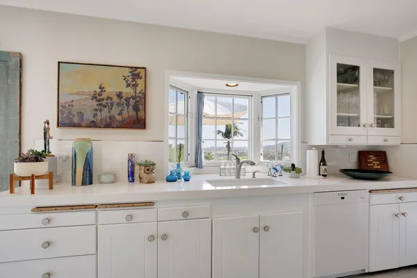 a kitchen with sink and mirror