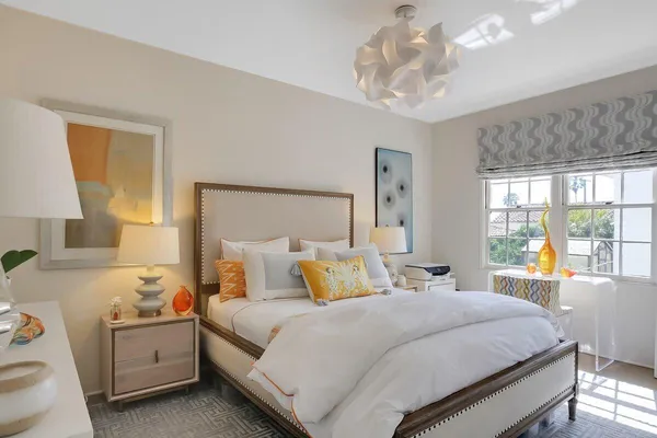 a bedroom with a large bed and a chandelier