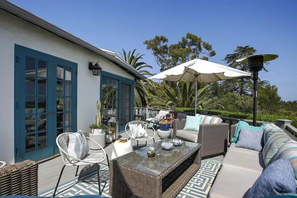 a view of a patio with couches table and chairs and potted plants