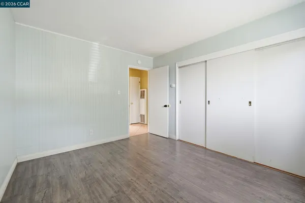 a view of an empty room with wooden floor