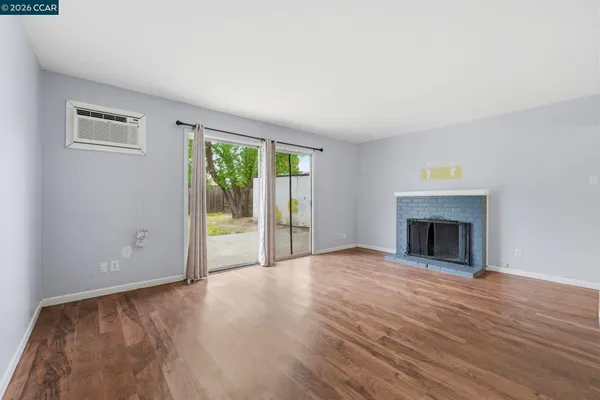 a view of an empty room with a window and fireplace