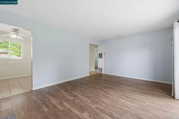 an empty room with wooden floor and windows