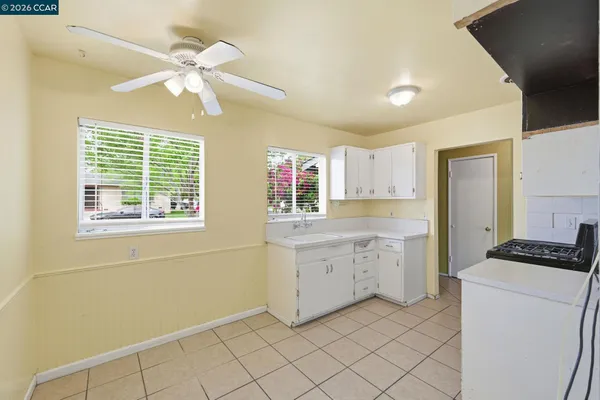 a kitchen with granite countertop cabinets a stove a sink and a window