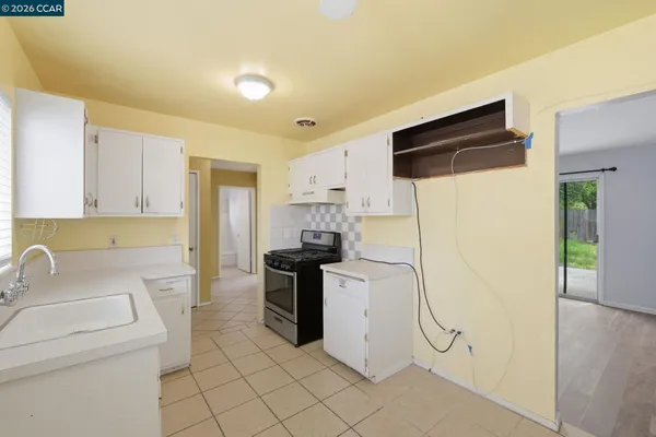 a kitchen with a sink a refrigerator and cabinets