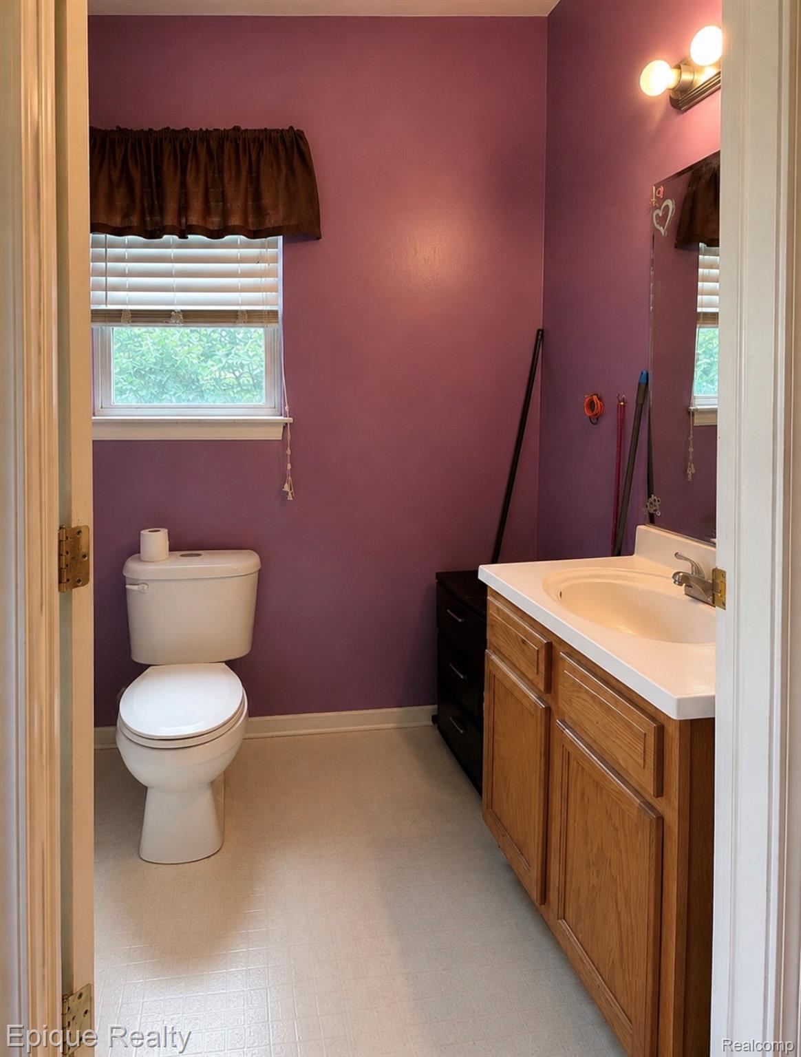 11619 Read Avenue Mount Morris, MI 48458 - Photo 8 of 10 Bathroom featuring a single window, white toilet, single vanity with a solid surface countertop, and light-toned flooring