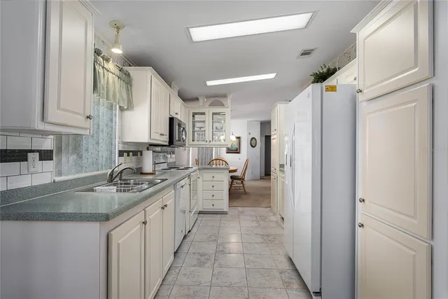 a kitchen with a refrigerator a sink and cabinets