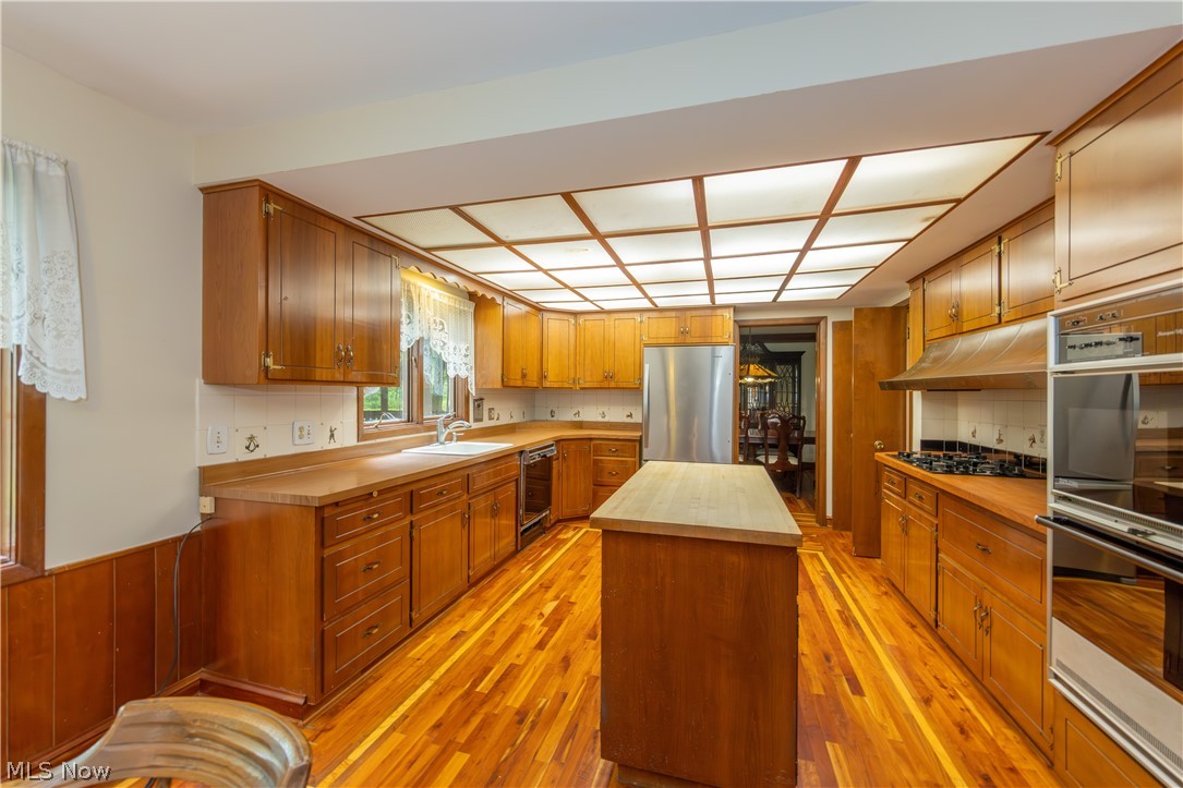 25001 Letchworth Road Beachwood, OH 44122 - Photo 8 of 50 Kitchen featuring wood-finish flooring, recessed ceiling lighting, wood cabinetry, a central island, and stainless steel appliances