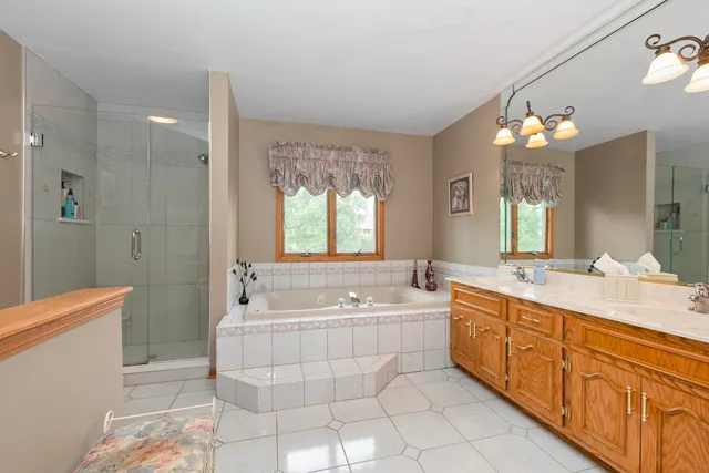 a spacious bathroom with a double vanity sink a large mirror and a bathtub