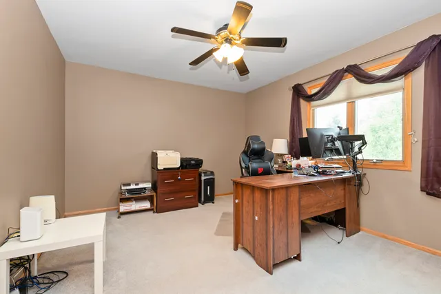 a view of a workspace with furniture and a window