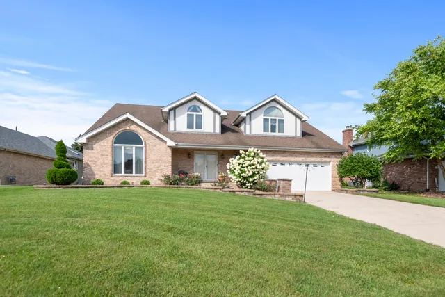 a front view of a house with a garden and yard