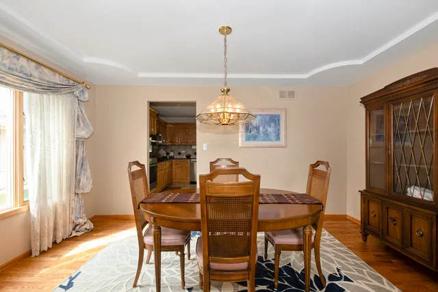 a dining room with furniture a chandelier and wooden floor