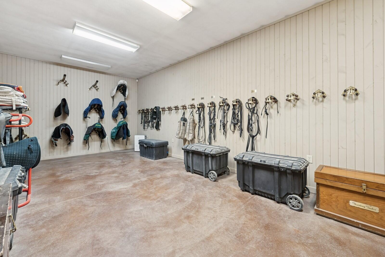 W1800 County Road B Bloomfield, WI 53128 - Photo 12 of 81 Organized tack room featuring bridle hooks, saddle storage, and open floor space for equipment management.