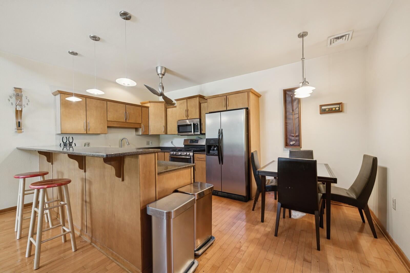 W1800 County Road B Bloomfield, WI 53128 - Photo 15 of 81 Open-concept kitchen and dining area featuring hardwood floors, generous cabinetry, and a functional layout ideal for everyday living.