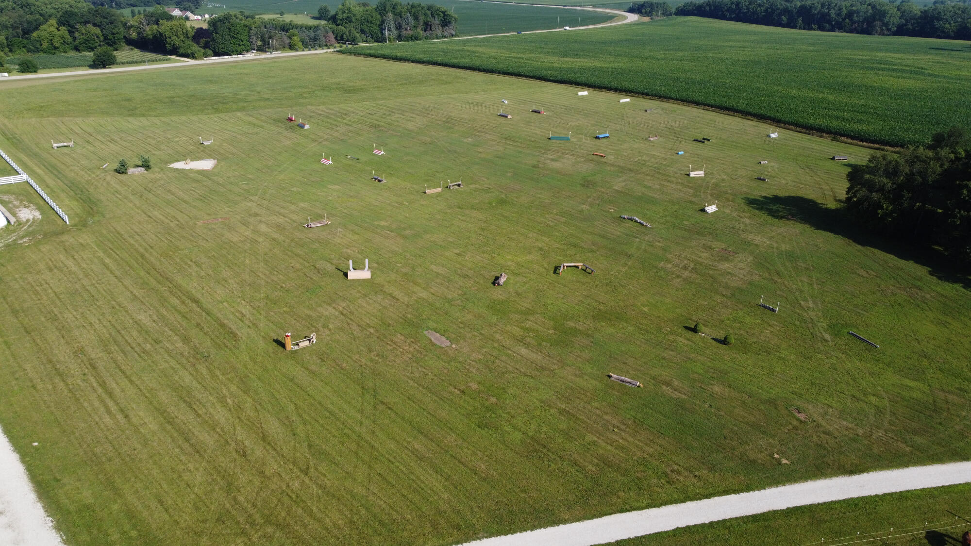W1800 County Road B Bloomfield, WI 53128 - Photo 20 of 81 Expansive view of the grass training fields featuring elements of the outdoor cross-country course, featuring a water obstacle, with level terrain and ample space for varied equestrian use.