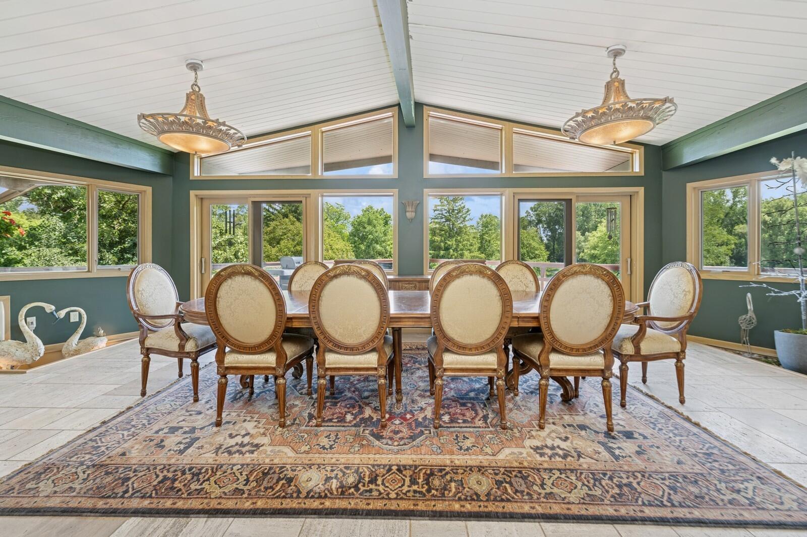 W1800 County Road B Bloomfield, WI 53128 - Photo 39 of 81 A spacious dining room with vaulted ceiling, large windows, and sliding doors that frame scenic outdoor views and fill the space with natural light.