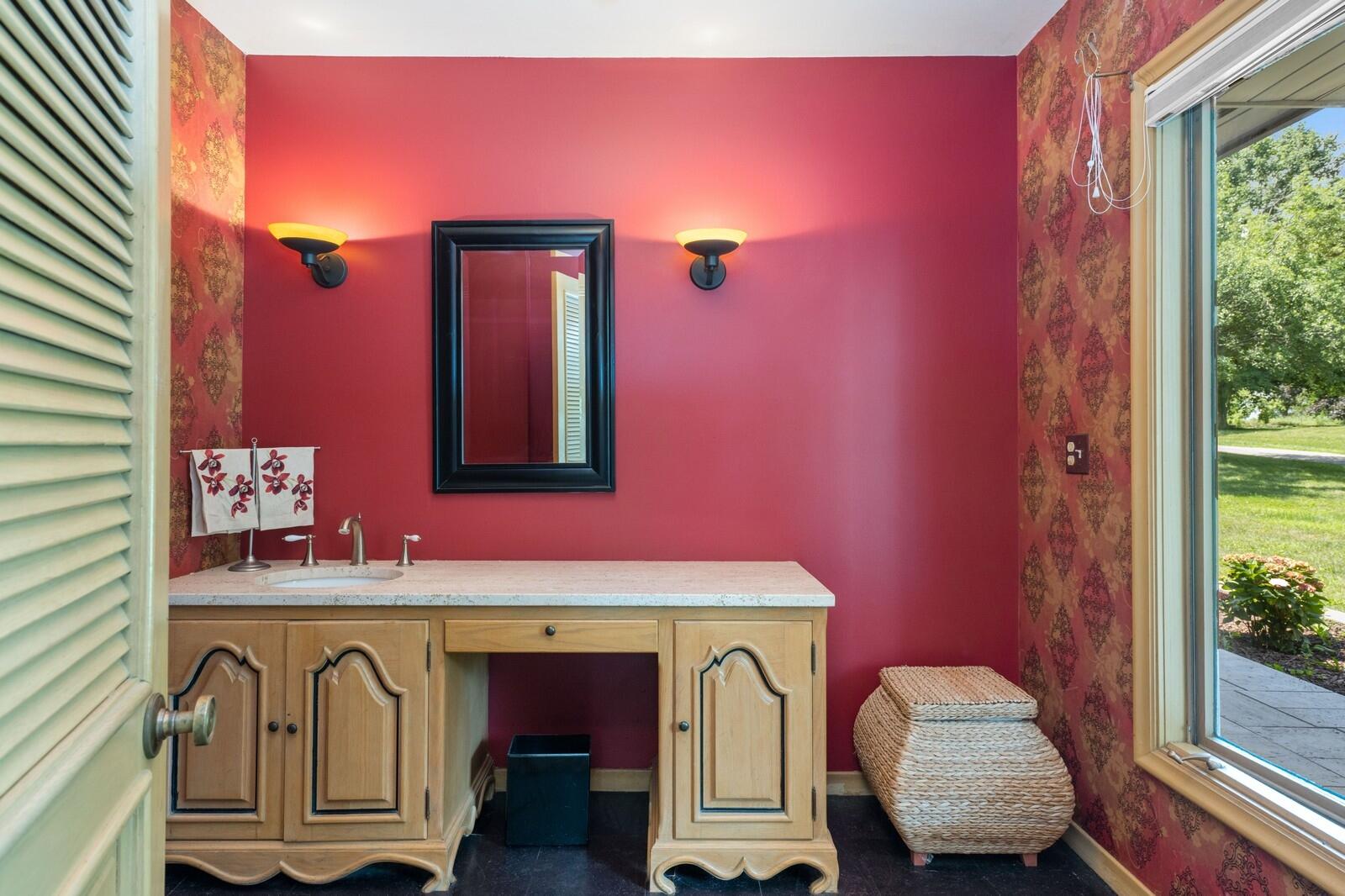 W1800 County Road B Bloomfield, WI 53128 - Photo 40 of 81 A stylish vanity area featuring custom cabinetry, solid-surface countertop, accent lighting, and a large window bringing in natural light.