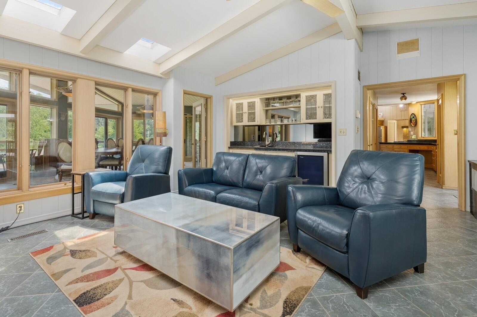 W1800 County Road B Bloomfield, WI 53128 - Photo 47 of 81 Comfortable family room with skylights, seating area, and a built-in bar, ideal for casual gatherings or relaxation.