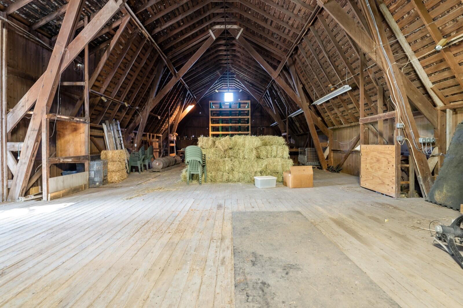 W1800 County Road B Bloomfield, WI 53128 - Photo 61 of 81 Spacious barn interior with open framing and high ceilings, ideal for hay storage, equipment, or flexible agricultural use.