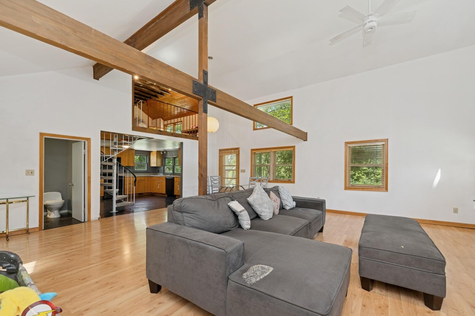 W1800 County Road B Bloomfield, WI 53128 - Photo 68 of 81 Bright living area with vaulted ceilings and an open connection to the kitchen and loft above.