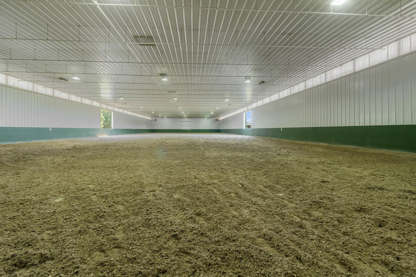 W1800 County Road B Bloomfield, WI 53128 - Photo 7 of 81 Expansive 80’ x 240’ single-span indoor riding arena featuring premium sand footing enhanced with GoldTex additive, a ceiling-mounted misting system, four high-capacity furnaces, and electric overhead doors providing year-round functionality and comfort.